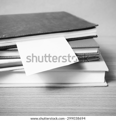 stack of book with sticky note on wood background black and white color tone style