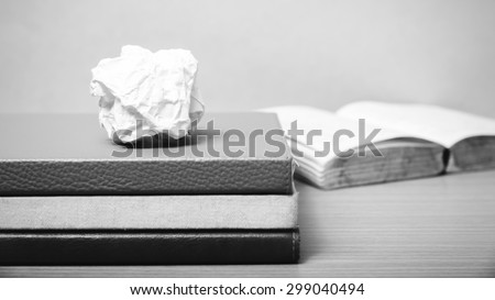 book and crumpled paper on wood background black and white color tone style