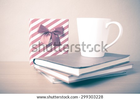 book with gift box and coffee mug on wood background vintage style
