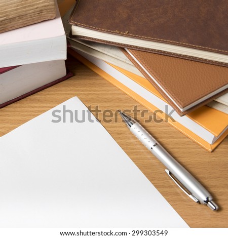 empty paper and pen with book on wood background