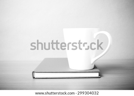 book and coffee mug on wood background black and white tone style
