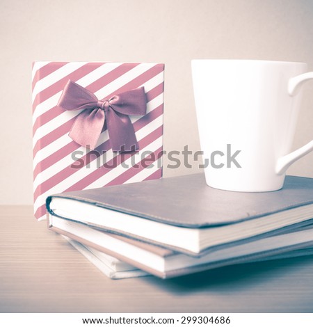 book with gift box and coffee mug on wood background vintage style