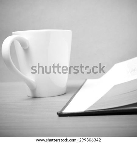 book and coffee mug on wood background black and white tone style