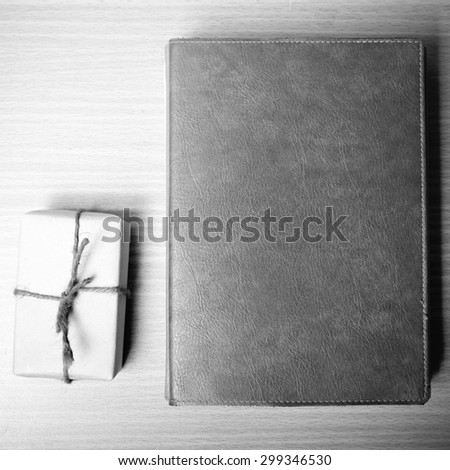 book with gift box on wood background black and white tone style