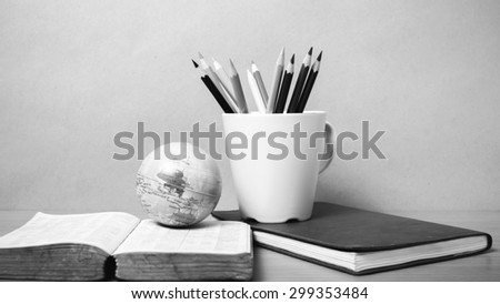 book and earth ball with color pencil on wood background black and white color tone style