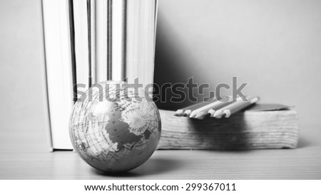 book and earth ball with color pencil on wood background black and white color tone style