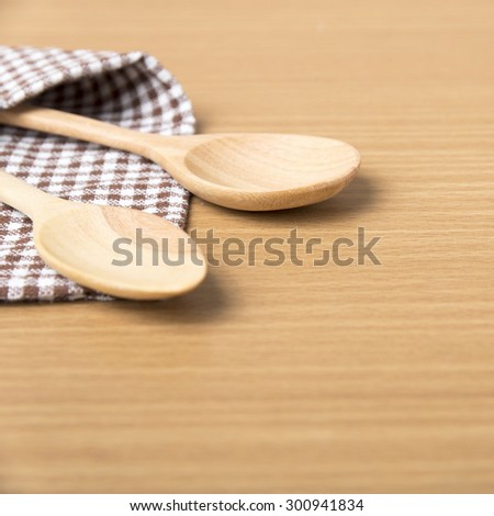 wood spoon and kitchen towel on table