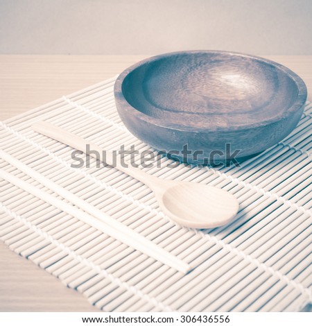 empty bowl with chopstick on wood table background vintage style