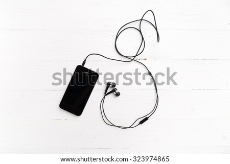 cellphone with earphone over white table