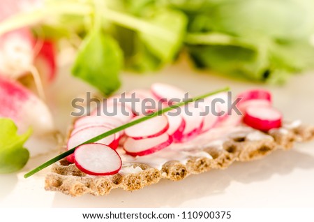 Sliced radish on whole wheat crisps with cream cheese and chives