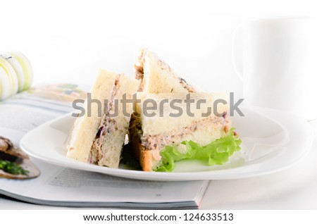 Breakfast of creamy tuna sandwiches with cup of tea and a journal