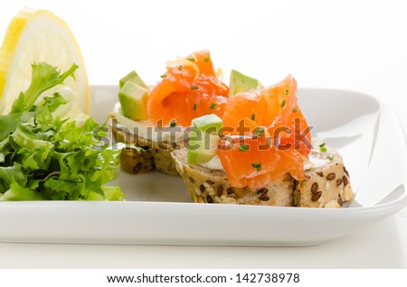 Canapes with smoked salmon, cream cheese and avocado cubes