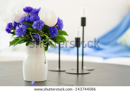 vase of blue and white flowers in modern white living room - home decor