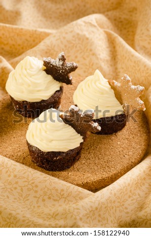 Christmas cupcake with snow flake cookie on top with christmas decorations on wooden background
