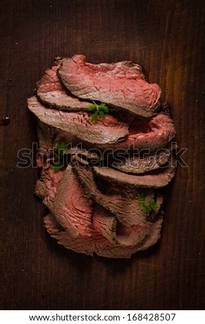 Juicy roast beef slices on cutting board