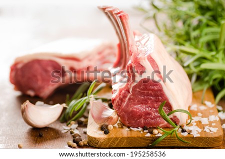 Raw lamb chops with spices and herbs close-up on wooden background