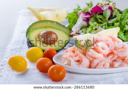 Shrimp salad ingredients - cooked, peeled shrimps, salad, tomato and avocado