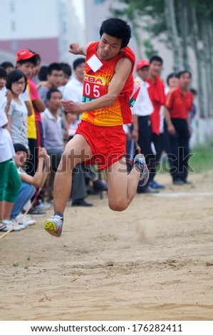 Xingtai City, Hebei Province, China - May 2012: On May 11, 2012 baixiang County Middle School Track and Field Games, student athletes performance in the long jump competition is very exciting.