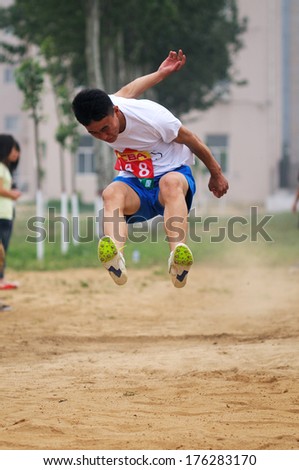 BAIXIANG COUNTY, HEBEI PROVINCE, CHINA - MAY 2013: On May 11, 2012 baixiang County Middle School Track and Field Games, student athletes performance in the long jump competition is very exciting.