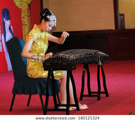 Shijiazhuang City, Hebei Province, China July 7: On July 7, 2012 in Hebei Province, China Youth Arts Festival Area, an unidentified girl ecstatic playing traditional Chinese instruments, the guqin.