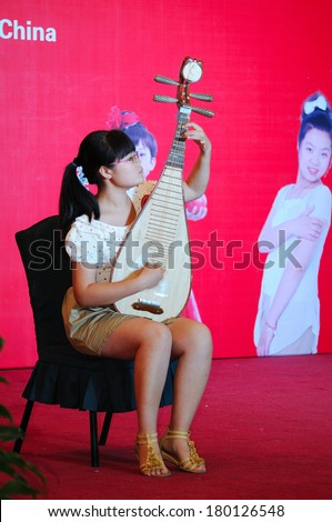 Shijiazhuang City, Hebei Province, China July 7: On July 7, 2012 in Hebei Province, China Youth Arts Festival Area, an unidentified girl ecstatic playing traditional Chinese instruments, the pipa.