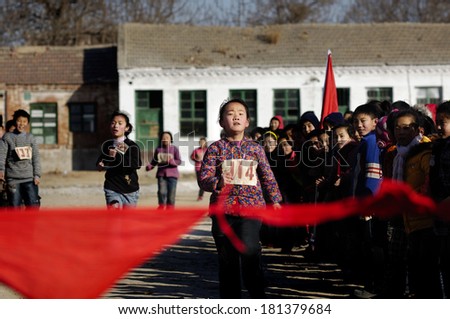 XINGTAI CITY, CHINA - 12 2010: In the December 31, 2010, baixiang County rural schools held a race game, unidentified little girl struggling to run toward the end of the sprint.