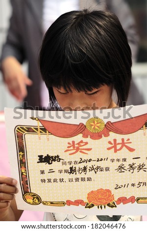 XINGTAI CITY, CHINA - MAY 27, 2011: In the May 27, 2011, a school for students winning awards and certificates The award-winning unidentified students are very happy and proud.