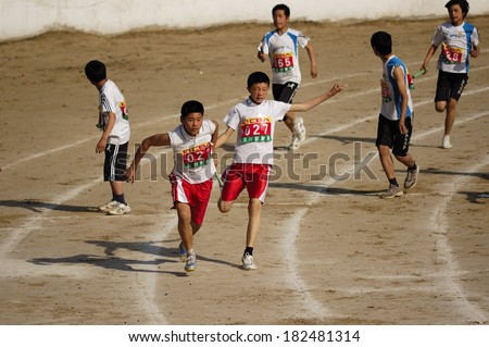 Xingtai City, China - May 12: In May 12, 2011, baixiang County Middle School Games were held. Unidentified student athletes in the four-way one hundred worked hard to win the game.