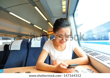 young asian woman use smartphone interior of train/subway