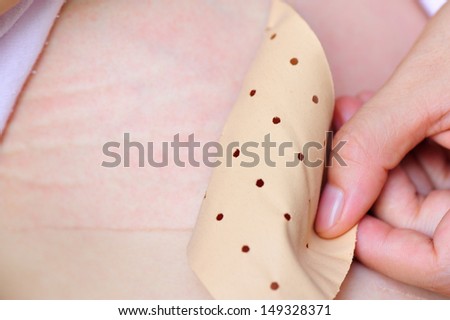 a woman using adhesive plaster on her injured body