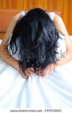 woman annoyed sitting on the bed clawing at the sheets in mad