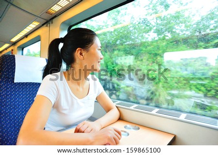 girl sitting on a train and looking out of the window smiling