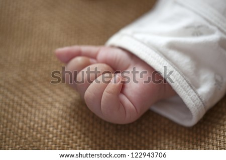 Baby little hand gripping on mat  in Summer
