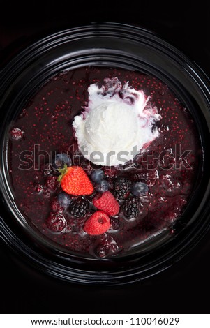 A Moody Shot of Vanilla Ice Cream and a Mixed Berry Fruit Reduction