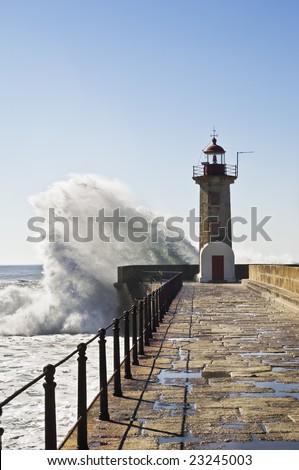 Huge waves breaking against the base of a lighthouse