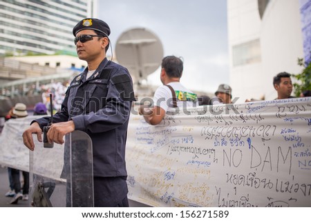 BANGKOK - SEPTEMBER 22 : Policeman on duty during Stop EHIA campaign at Pathum Wan Intersection on September 22,2013 in Bangkok, Thailand.