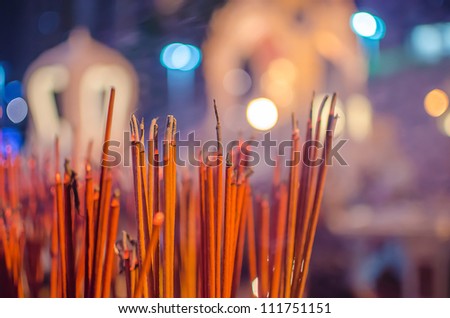 Red incense sticks burning in bokeh night
