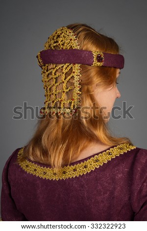 beautiful young girl in a historical dress on gray background