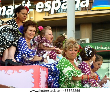 ALGECIRAS, SPAIN - JUNE 19: Beginning of the fair June 19, 2010 in Algeciras, Spain. Women in the traditional parade. During the parade te participates throwing sweets into the crowds of people