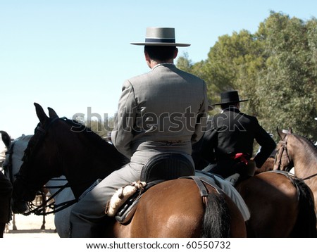 horse rider with traditional spanish rider suit photographed from backside