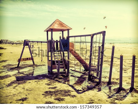 retro styled very atmospheric photography of a shabby playground on the beach after flood