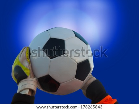 goalkeeper catches football / soccer-ball in a floodlight match