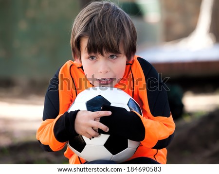 Goalkeeper Boy with football soccer / shirt and ball in a park