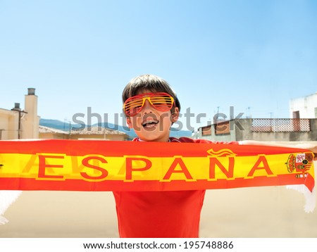young boy with  funny fan glasses supports the spanish soccer / football team