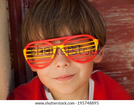 young boy with  funny fan glasses supports the spanish soccer / football team