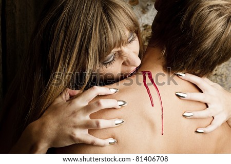 Female Vampire is biting in a young man\'s neck
