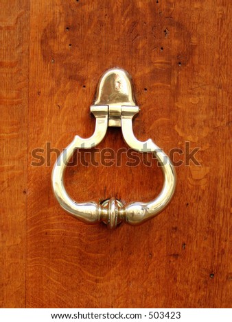 golden door knocker on luxury wood