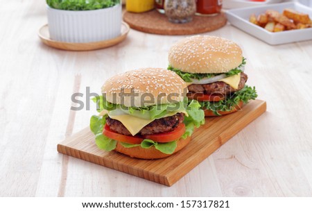 Two Grilled Homemade Hamburgers On A Wooden Board In Environment From The Breakfast Table.