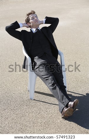 Young businessman relaxing in chair at beach