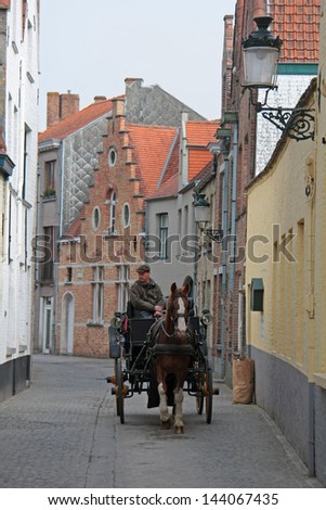 BRUGES, BELGIUM - MAY 3: Tourist transport (horse carriages) on the streets of Bruges on May 3, 2013. One of the main tourist attractions in the commercial heart of medieval-looking city of Bruges.